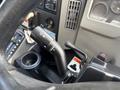 A close-up view of the gear shift and control stalk in a 2012 International DuraStar 4300 truck showing various knobs and buttons