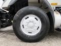 Close-up of a white rim and tire from a 2012 International 7400 vehicle showing the tire tread and bolt pattern