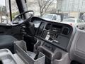 Interior view of a 2005 Freightliner M2 106 cab featuring the steering wheel dashboard controls and an audio system with various buttons and knobs