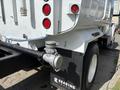 A 2016 Ford F-750 truck with a white body featuring red taillights and a black exhaust system marked with the logo of Reading Truck