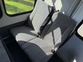 A gray upholstered rear bench seat with a seatbelt inside a vehicle