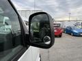 Close-up of the side mirror of a 2004 Chevrolet Express with a reflection visible in the glass