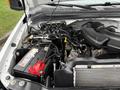 An open hood of a 2008 Ford F-350 showcasing the engine compartment with visible wiring components and a red battery in focus