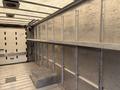 Interior of a 2018 Ford Econoline cargo van showing metal walls and a flat loading area with a step up on one side