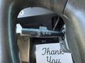 A close-up of the steering column of a 2009 Morgan Olson Workhorse W62 showing a control stalk with light and wiper functions next to a napkin that says Thank You