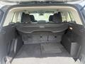 The interior of a 2014 Ford Escape showing an empty cargo space with a flat floor and a retractable cover over the storage area