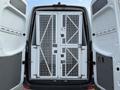 A 2012 Mercedes-Benz Sprinter van with open rear doors revealing a metal caged partition system inside