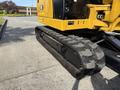 A yellow 2022 Caterpillar 306 excavator with a rubber track prominently shown in the foreground
