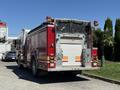 A red 2004 American LaFrance Eagle fire truck with chrome detailing and multiple lights on top parked on a street