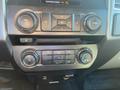 The interior dashboard controls of a 2017 Ford F-150 featuring audio and climate control knobs and buttons
