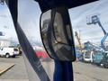 The image shows the side mirror of a 2023 Bitimec SC415 reflecting vehicles and machinery in its view