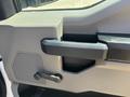 Interior door panel of a 2019 Ford F-150 featuring a sturdy handle and controls for window operation
