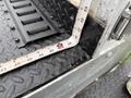 A measuring tape is placed on the textured black surface of a 2015 Ford F-350 SD truck bed showing measurements in inches