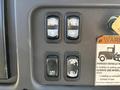 Control panel featuring three switches for various functions of a 2006 Freightliner M2 106 including mirr heat and a warning label detailing vehicle loading instructions
