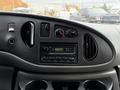 Interior dashboard of a 2006 Ford Econoline featuring controls for climate, radio, and storage compartments