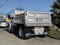 A 2017 Ford F-650 Super Duty truck with a silver dump bed and AMG branding on the rear mud guards