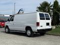 2013 Ford Econoline van in white with a simple design and large rear doors parked at an angle