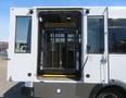 A 2020 Chevrolet Express with an open rear door showing a wheelchair lift inside the vehicle