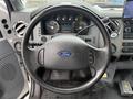 Steering wheel of a 2011 Ford F-650 with dashboard gauges and controls visible in the foreground including a digital display and various buttons
