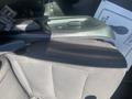 A close-up view of the center console and armrest of a 2020 Ford Explorer featuring a button and textured black fabric upholstery