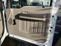 A beige interior door panel of a 2008 Ford F-550 featuring a handle and ridged design elements