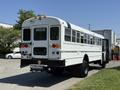 A 2009 International 3000 CE school bus in white with multiple windows and a rear emergency door