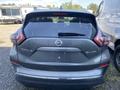 A 2017 Nissan Murano SUV seen from the rear with a gray exterior and the model name and trim SL AWD displayed on the back