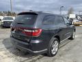 A 2015 Dodge Durango in dark gray with chrome accents and a sleek design viewed from the rear angle showcasing its modern styling and distinctive tail lights