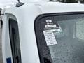 A 2010 Suzuki Carry with a sticker displaying a certificate of approval and the months of the year covered in raindrops