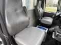 Interior of a 2013 International Workstar 7500 featuring two gray leather seats with a control panel on the floor between them