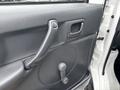 Close-up of a 2010 Suzuki Carry door interior showing the door handle and window crank in gray plastic