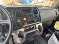The interior dashboard of a 2013 Freightliner 114SD featuring various controls gauges and a radio located in the center console