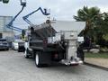 A 2012 International TerraStar truck with a large mounted hopper at the rear used for transporting materials or as a salt spreader in winter maintenance