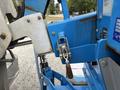 Close-up of a blue 2016 Genie TZ-34/20 aerial lift with visible hydraulic components and a safety latch mechanism