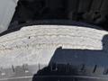 A close-up view of a worn tire tread from a 2011 International 4300 showing uneven wear and visible grooves