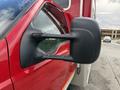 A side view mirror of a red 2007 Ford F-550 with a black housing and dual arms