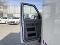 A 2023 Ford E-450 with its driver's side door open showcasing the interior door panel and handle