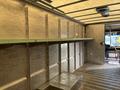Interior view of a 2018 Ford Econoline cargo van with metal shelves and a clean, empty space for storage