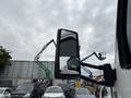 A 2025 Peterbilt 536 truck with a side mirror reflecting its surroundings
