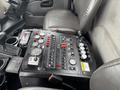 Control panel of a 2013 International DuraStar 4300 featuring multiple gauges buttons and switches for various functions