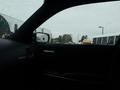 The interior view of a 2017 Dodge Charger showing the driver's side with raindrops on the window and the cabin's dark materials