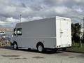A white 2017 Freightliner MT45 box truck with a closed rear cargo door and smooth sides parked on a street