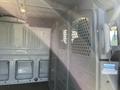 Interior view of a 2017 Ford Transit van showing a partition with perforated metal and an empty cargo area