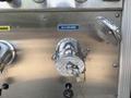 A shiny chrome discharge valve labeled No. 3 attached to a metallic panel with various other fittings and controls