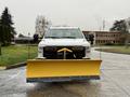 A 2023 Ford F-250 with a yellow snow plow attached to the front