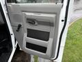 A 2022 Ford Econoline's door interior featuring a grey panel with a handle and storage compartment