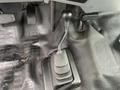 A black manual gear shifter for a 2014 Ford F-350 SD positioned on a textured floor mat inside the vehicle