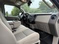 Interior view of a 2008 Ford F-450 SD featuring a gray cloth seat and a console with storage space alongside the dashboard displaying controls and features