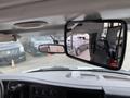 The interior view of a 2020 Chevrolet Express showing the dashboard and rearview mirror reflecting the outside vehicles