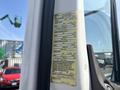 A yellow vehicle information label affixed to the driver-side door frame of a 2014 Freightliner M2 106 displaying specifications and identification details